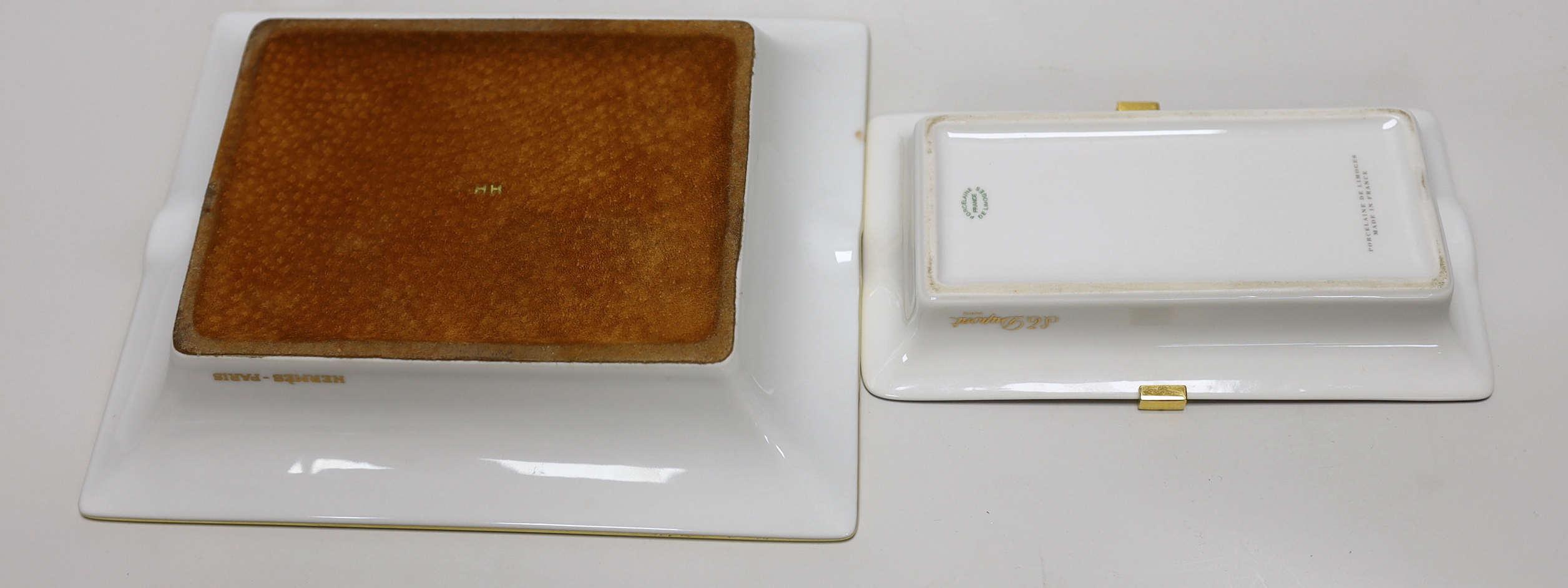A Hermes-Paris porcelain cigar ashtray decorated with a stylised fish and a similar gilt metal mounted example by Limoges for DuPont, the largest 20cm wide